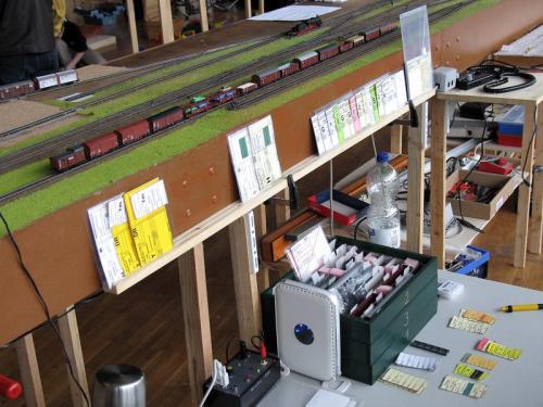 Im Bahnhof Finkenheerd steht eine Reihe Wagen, in der Holzleiste davor stecken die Wagenkarten dazu.